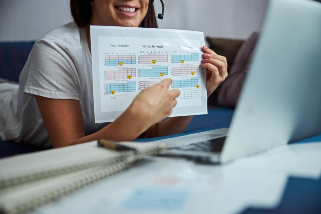 Cheerful female doctor consulting pregnant woman online